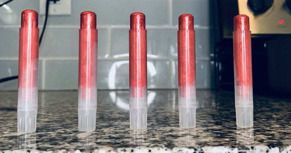 Thin tubes filled all the way with pink mica tinted lip balm.