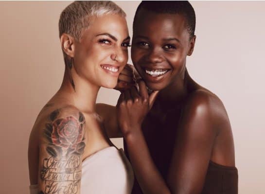 Two women modeling natural cosmetics with different skin tones.