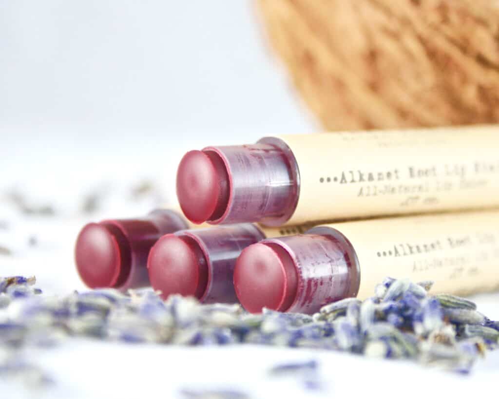 Alkanet-tinted lip balm on top of lavender buds