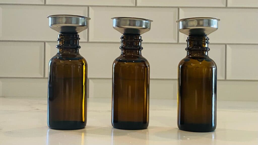 Amber bottles filled with carrier oils for the all natural dry skin facial serum recipe.